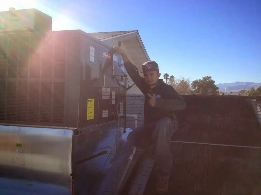 HVAC technician performing AC Tune-Up on a rooftop unit in Birch Run